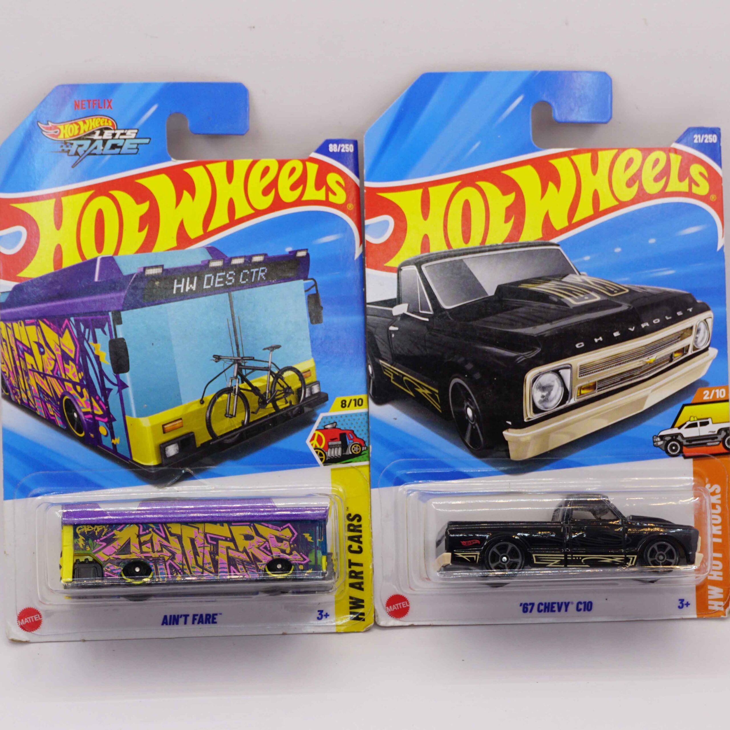Hot Wheels Mainlines die-cast cars, featuring black '67 Chevy C10 pickup and Ain't Fare fantasy art bus, 2025 releases at RACEiN PARC